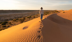 woman walking on Birdsville Big Red sand dune